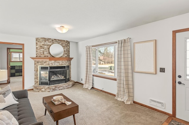 living area featuring a wealth of natural light, visible vents, a brick fireplace, and carpet flooring