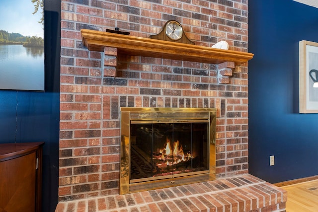 room details featuring a brick fireplace and hardwood / wood-style floors