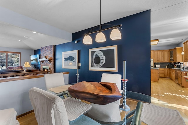 dining area with lofted ceiling and light wood-type flooring