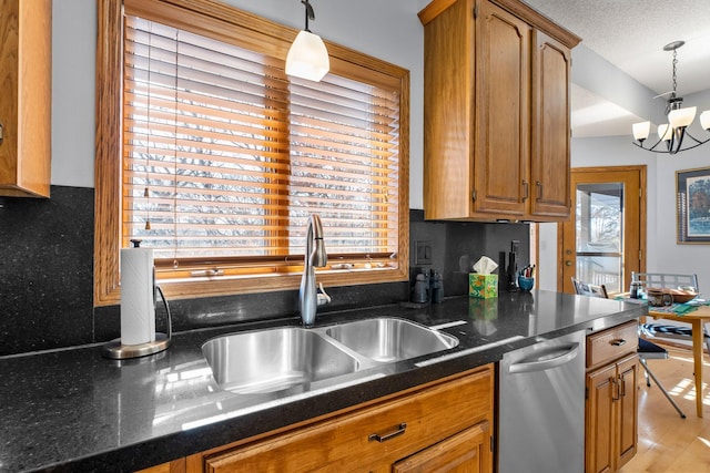 kitchen featuring sink, hanging light fixtures, a textured ceiling, dishwasher, and a notable chandelier