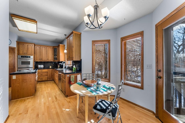 kitchen with pendant lighting, sink, appliances with stainless steel finishes, tasteful backsplash, and a kitchen island