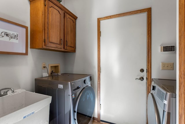 laundry room featuring washer and dryer, sink, and cabinets