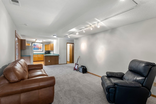 living room featuring rail lighting, light carpet, and a textured ceiling