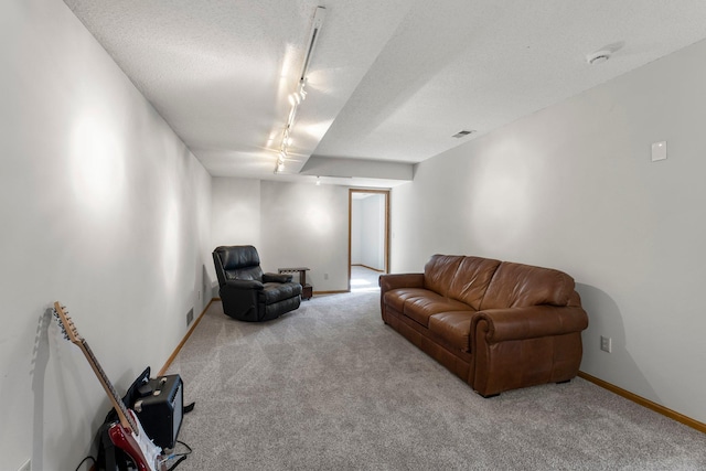 sitting room with light carpet, rail lighting, and a textured ceiling