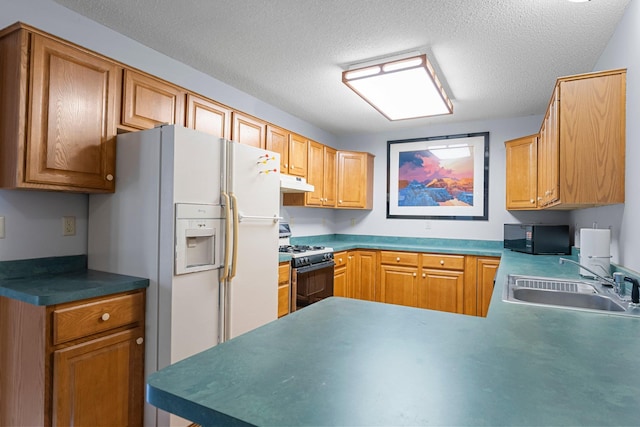 kitchen featuring sink, gas range, white refrigerator with ice dispenser, and a textured ceiling