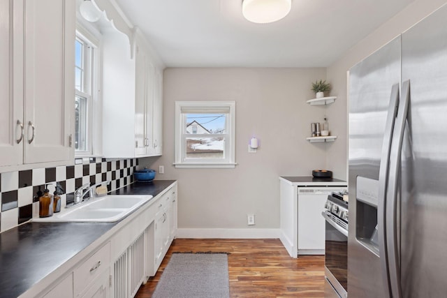 kitchen featuring appliances with stainless steel finishes, light hardwood / wood-style flooring, decorative backsplash, and white cabinets