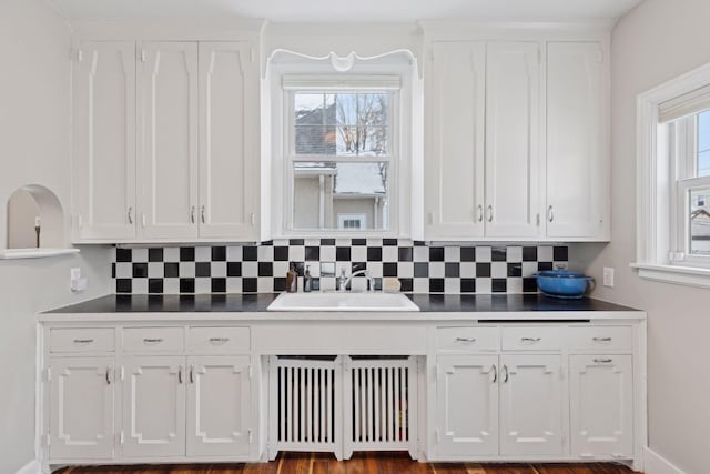 kitchen with sink, white cabinets, and decorative backsplash