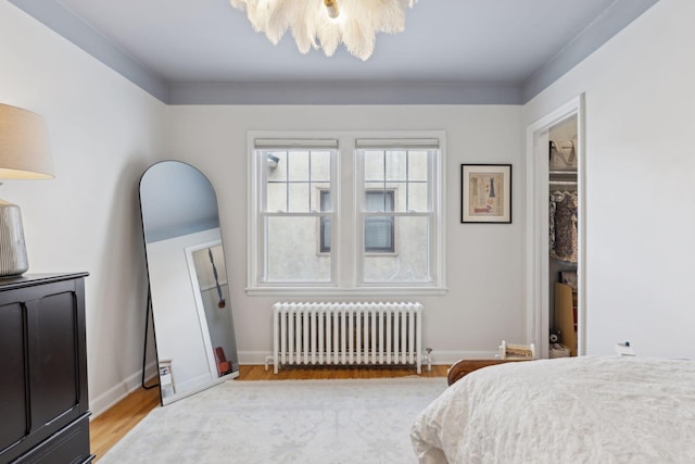 bedroom with radiator heating unit and light wood-type flooring