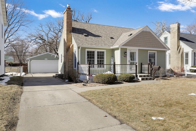 view of front facade featuring a detached garage, a porch, an outdoor structure, a front yard, and a chimney