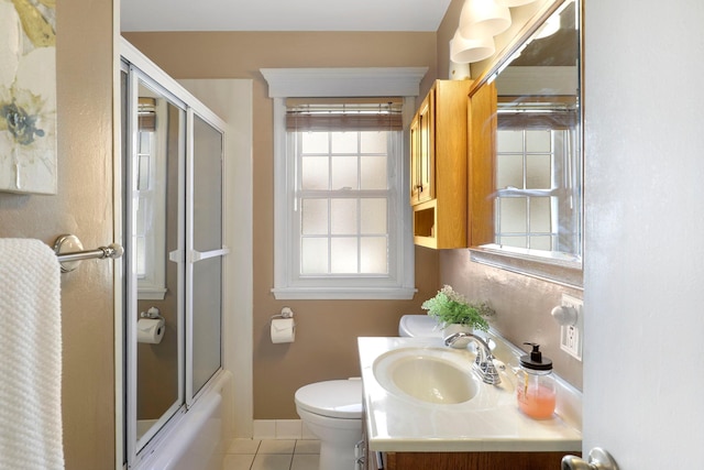 full bath with vanity, baseboards, shower / bath combination with glass door, tile patterned floors, and toilet