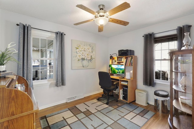 office area featuring visible vents, baseboards, ceiling fan, and wood finished floors