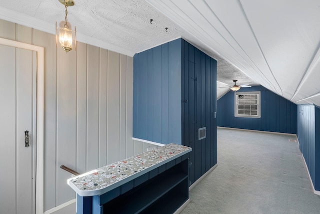 mudroom featuring lofted ceiling, wooden walls, carpet floors, and ceiling fan