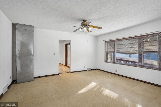 carpeted spare room featuring ceiling fan and a textured ceiling