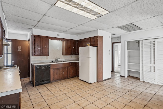 kitchen with sink, dishwasher, white refrigerator, and a drop ceiling