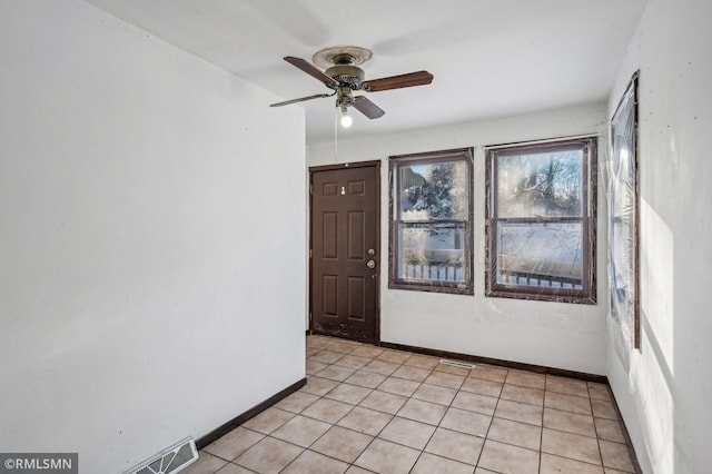 unfurnished room with light tile patterned floors and ceiling fan