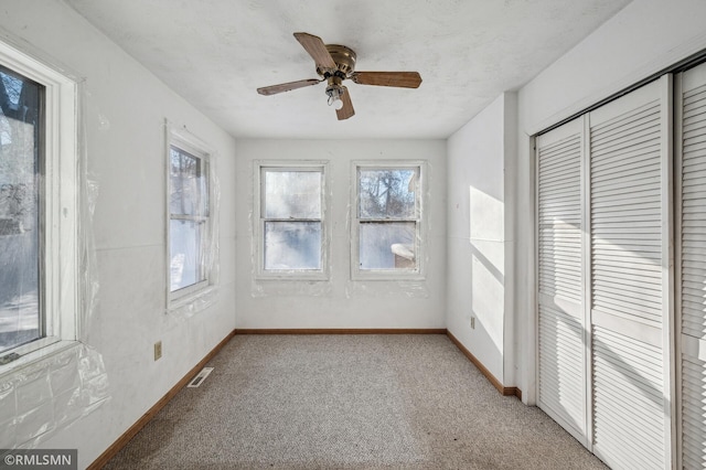 unfurnished sunroom with ceiling fan