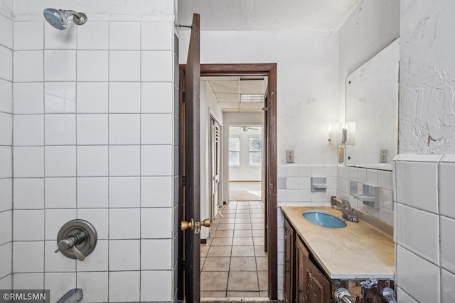 bathroom with vanity, tiled shower / bath, tile walls, and tile patterned flooring