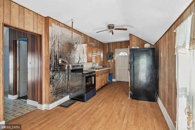 kitchen with vaulted ceiling, ceiling fan, sink, wood walls, and black appliances