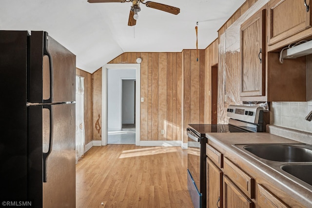 kitchen featuring light hardwood / wood-style flooring, stainless steel electric range, sink, black fridge, and lofted ceiling