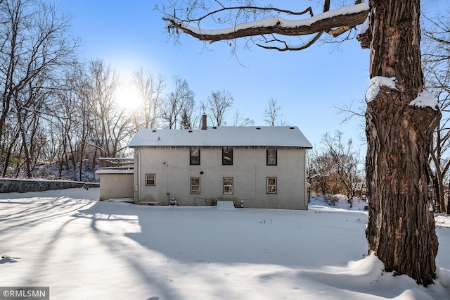 view of snow covered back of property