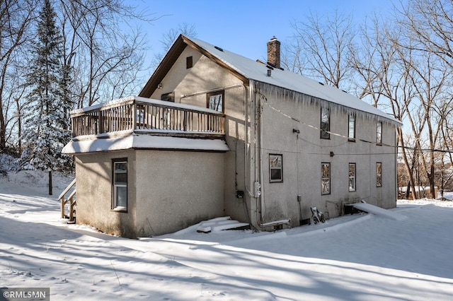 view of snow covered rear of property