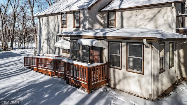 snow covered property with a wooden deck