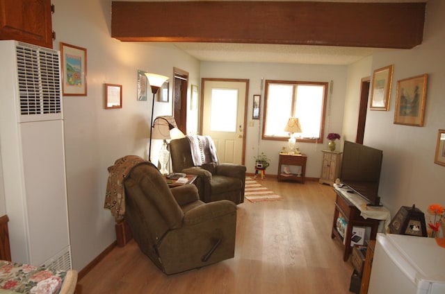 living room with beam ceiling and light hardwood / wood-style floors