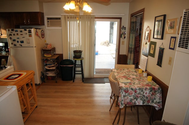 dining room with light hardwood / wood-style flooring and a wall unit AC