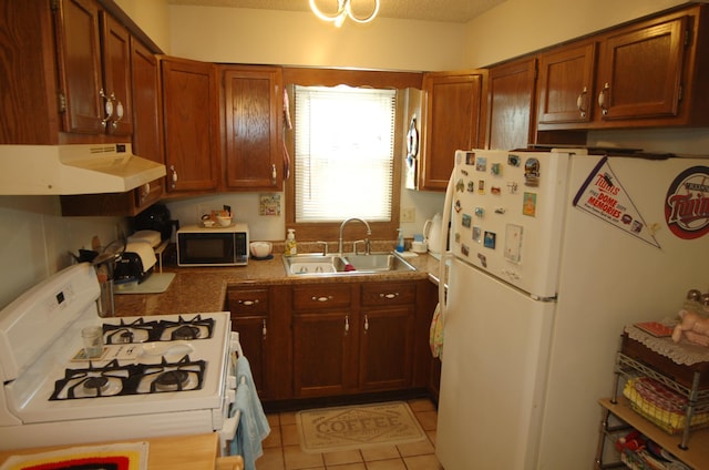 kitchen with white appliances, sink, and light tile patterned floors