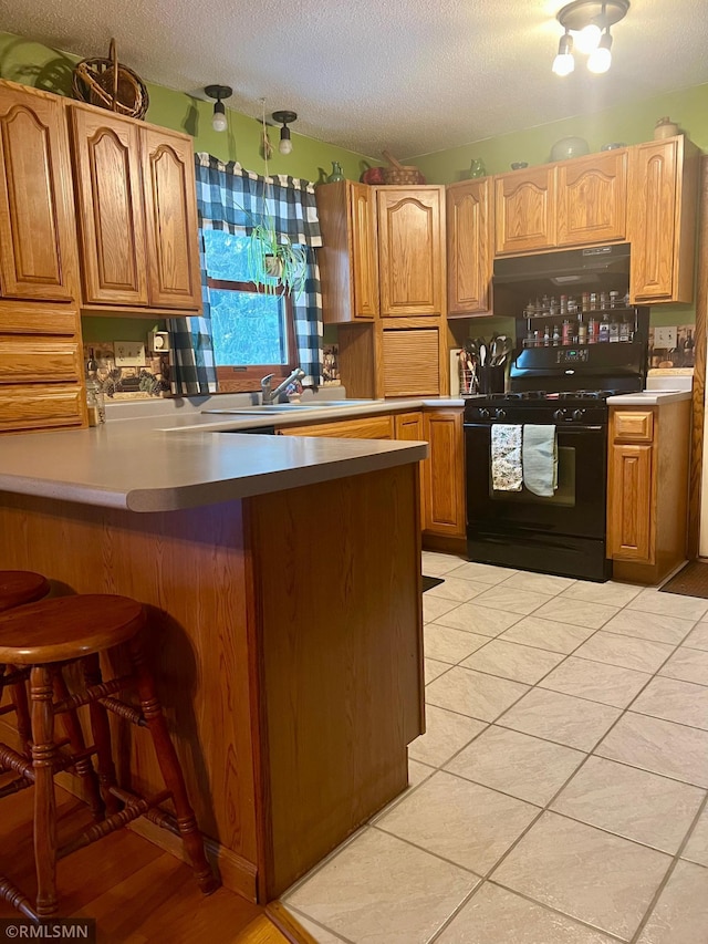 kitchen featuring sink, black range with gas cooktop, a textured ceiling, and light tile patterned flooring