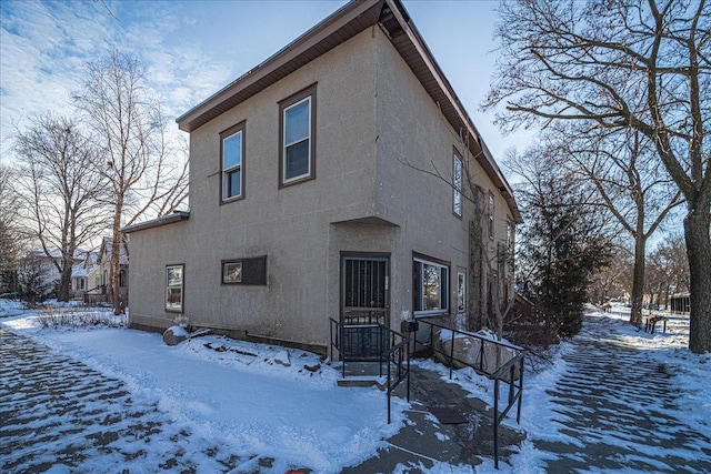 view of snow covered rear of property