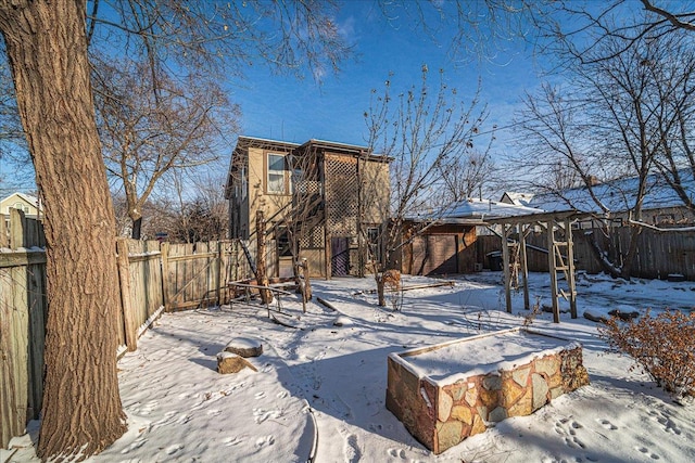 view of snow covered back of property