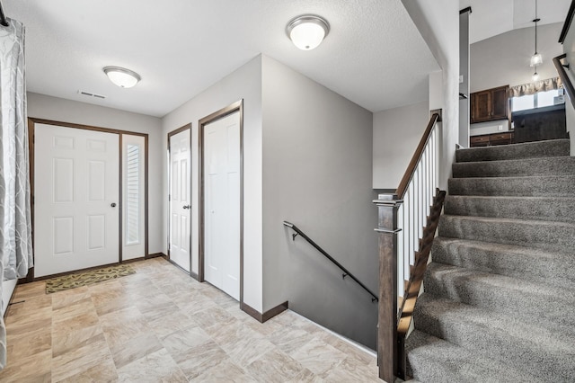 foyer entrance with a textured ceiling