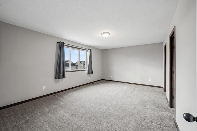 carpeted empty room featuring a textured ceiling