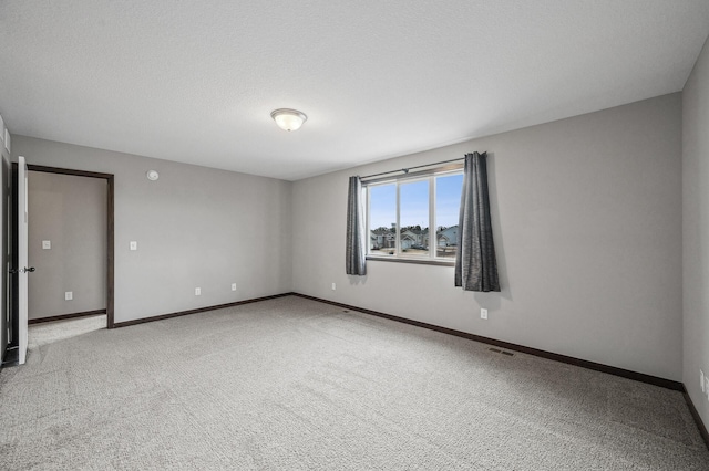 carpeted spare room featuring a textured ceiling