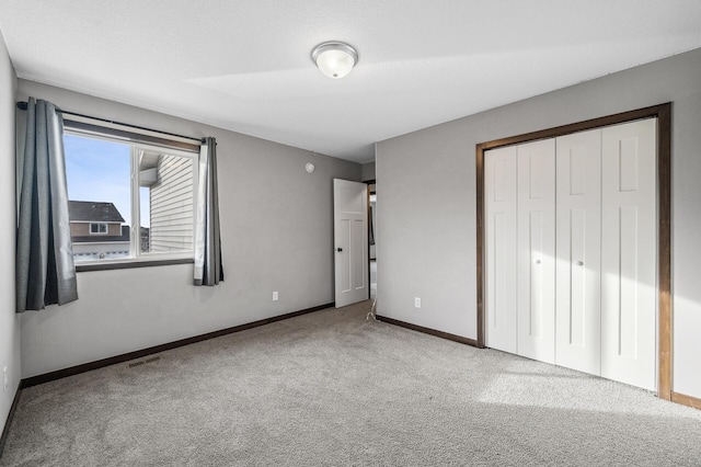 unfurnished bedroom featuring light colored carpet and a closet