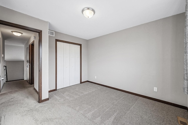 unfurnished bedroom with light carpet and a closet