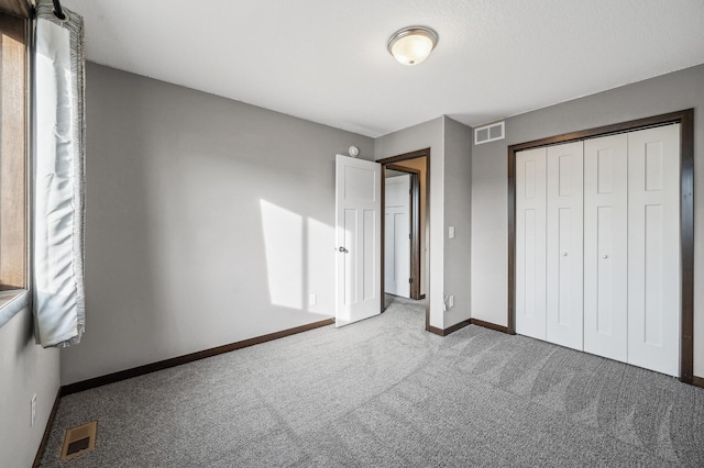 unfurnished bedroom with carpet flooring and a closet