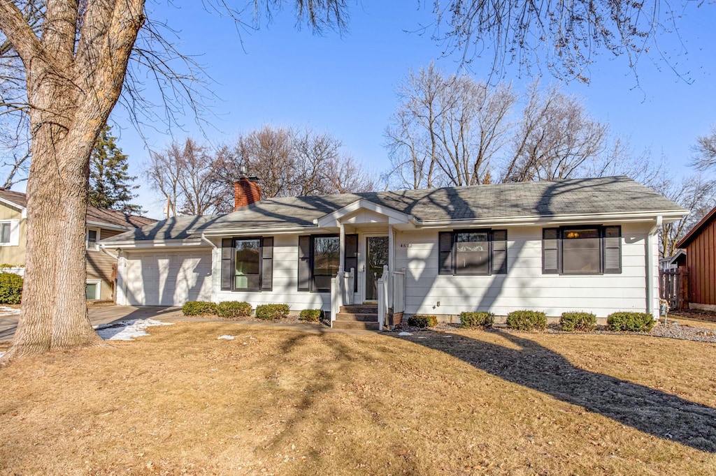 ranch-style home featuring a garage and a front yard