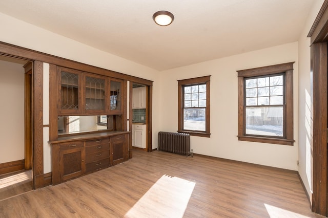 interior space with radiator and hardwood / wood-style floors