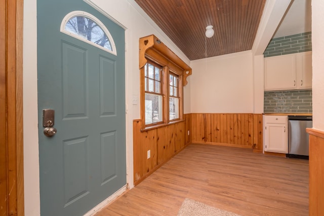 foyer with light hardwood / wood-style flooring, ornamental molding, plenty of natural light, and wooden ceiling