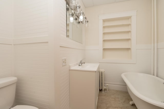 bathroom featuring built in shelves, tile patterned floors, toilet, vanity, and a bathing tub