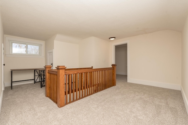 bonus room featuring vaulted ceiling, light carpet, and a textured ceiling