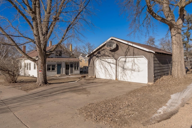 view of front facade featuring a garage and an outbuilding