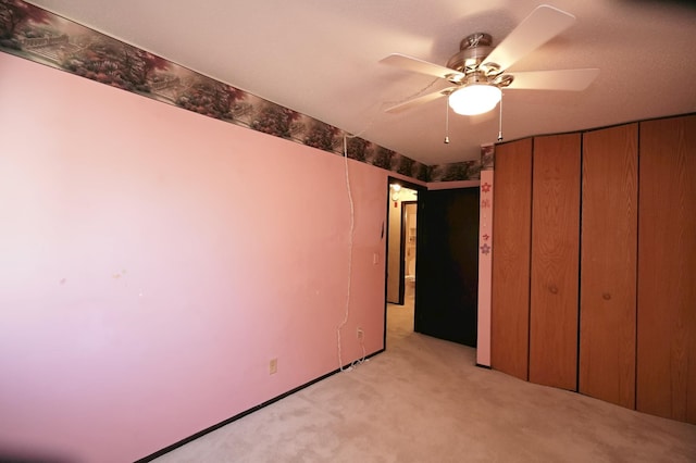 unfurnished bedroom with light colored carpet, a closet, and ceiling fan