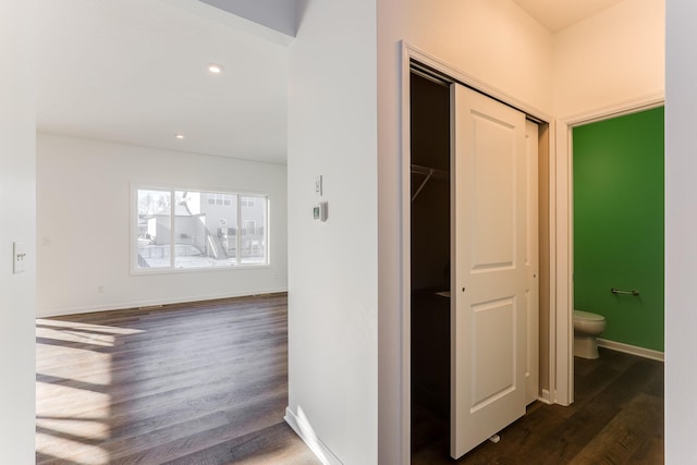 hall featuring dark wood-style flooring, recessed lighting, and baseboards