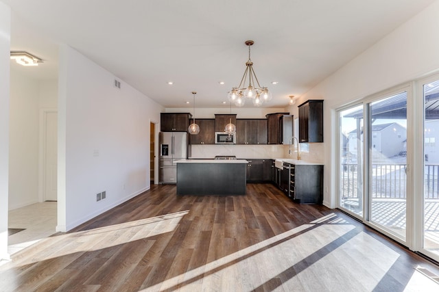 kitchen with visible vents, appliances with stainless steel finishes, a center island, light countertops, and pendant lighting