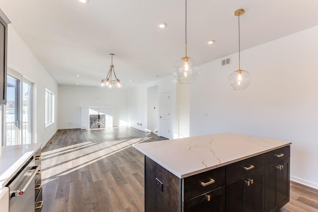 kitchen with hanging light fixtures, open floor plan, wood finished floors, and a center island