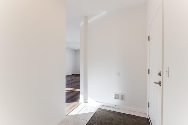 interior space featuring light tile patterned floors, visible vents, and baseboards