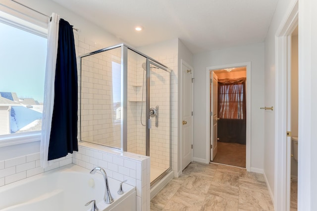 bathroom featuring a stall shower, toilet, baseboards, and a bath